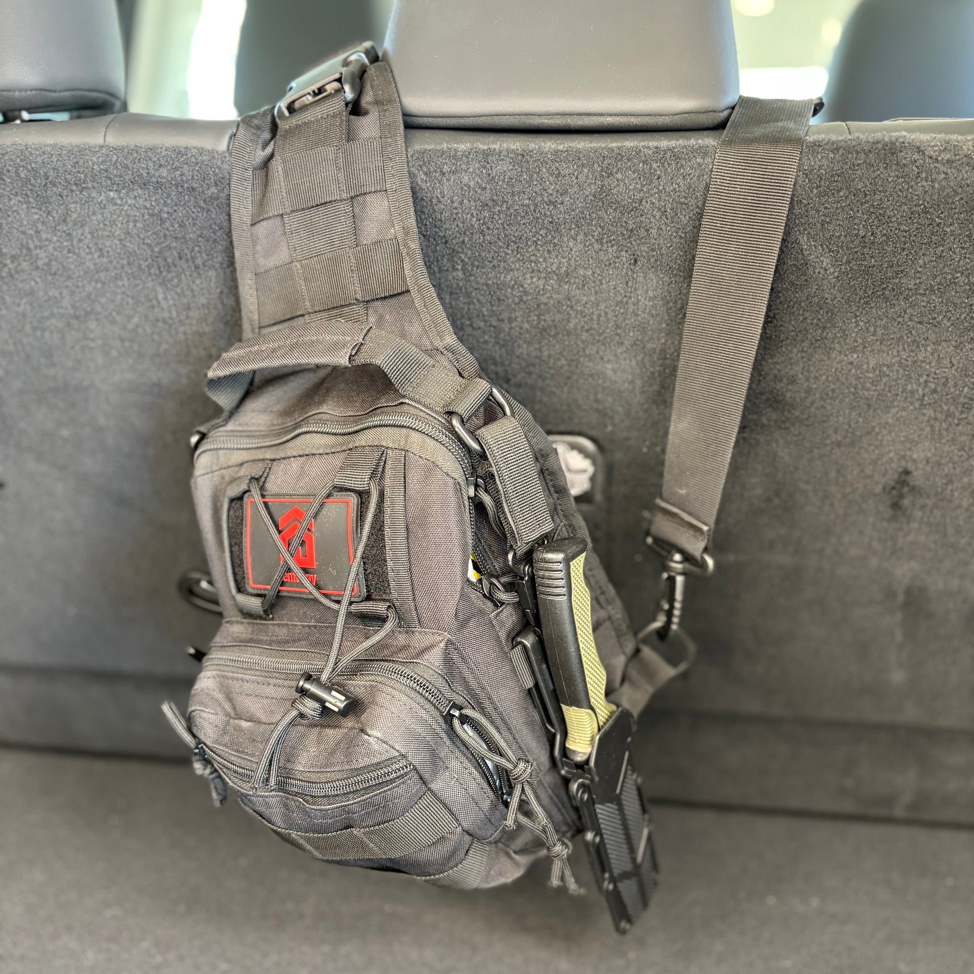 Tactical pouch with a visible brand logo attached to a car seat.