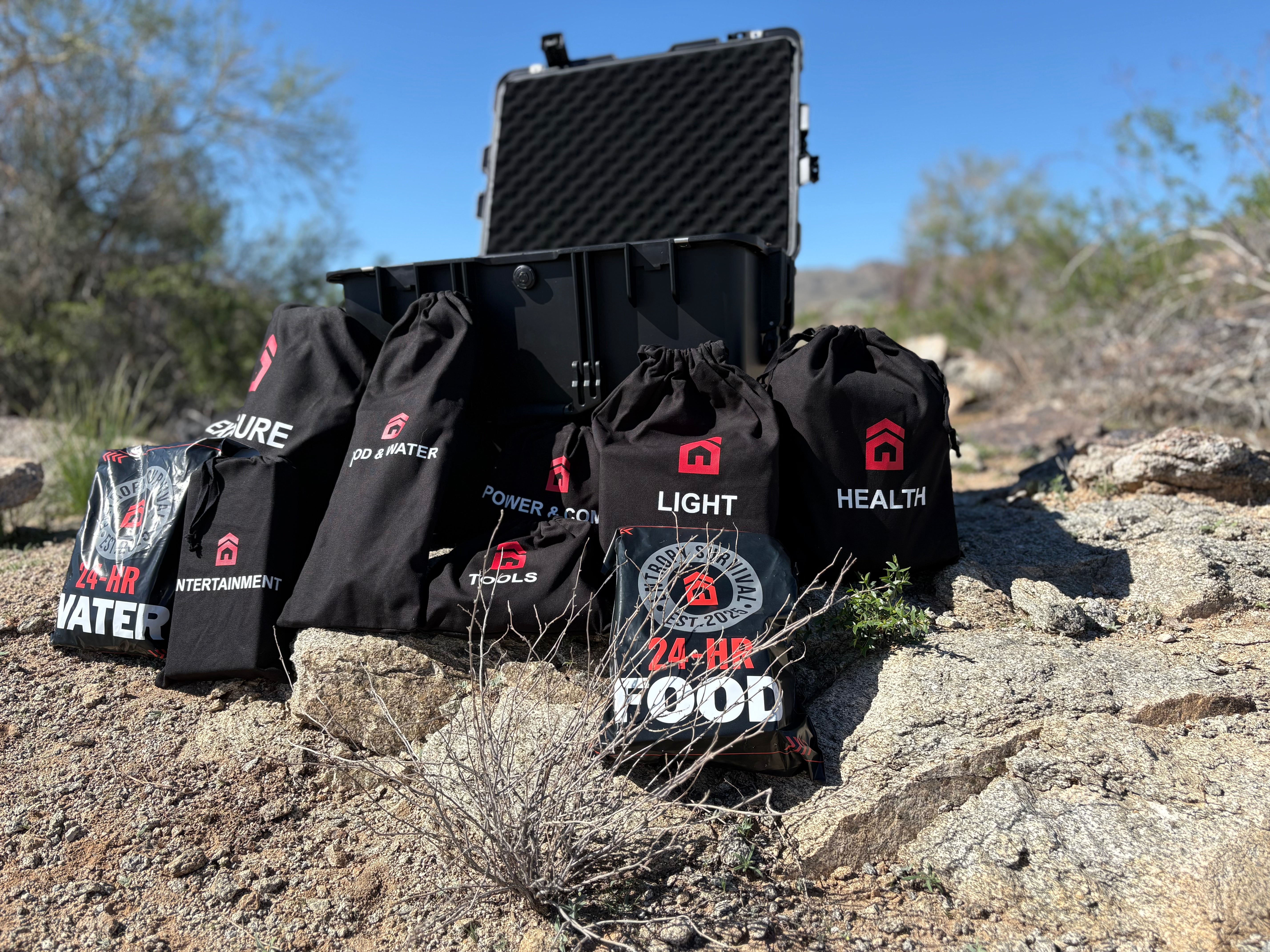 Black survival bags with labels on a rocky landscape